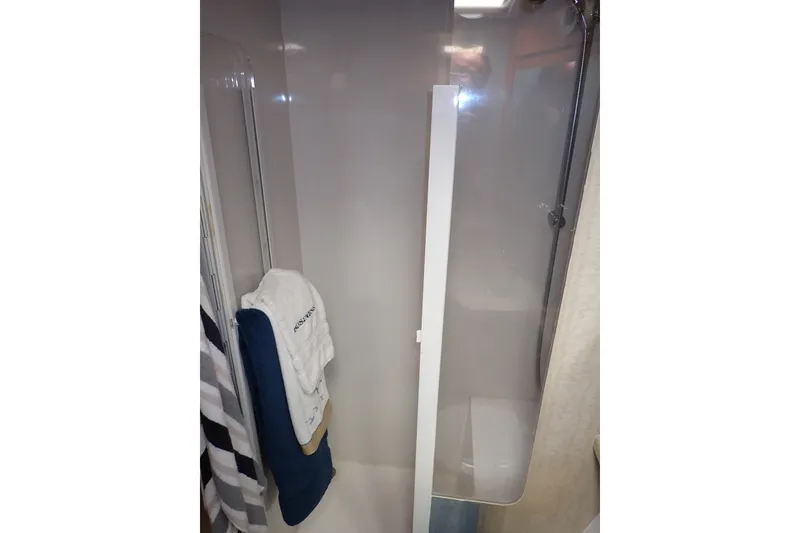 Slide: The Image of Shower area in a 2005 Bertram 390 boat with towels hanging. - 98