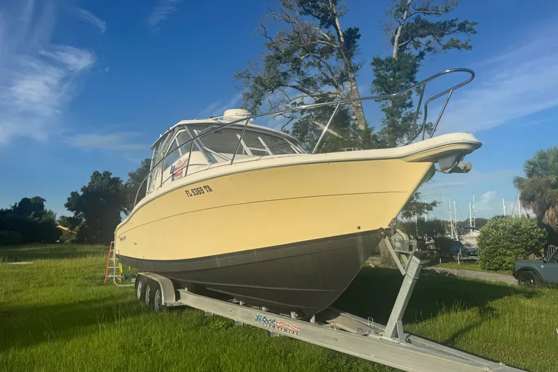 Slide: The Image of 2006 Pro-Line 35 Express boat on trailer in grassy area, under clear blue sky. - 25