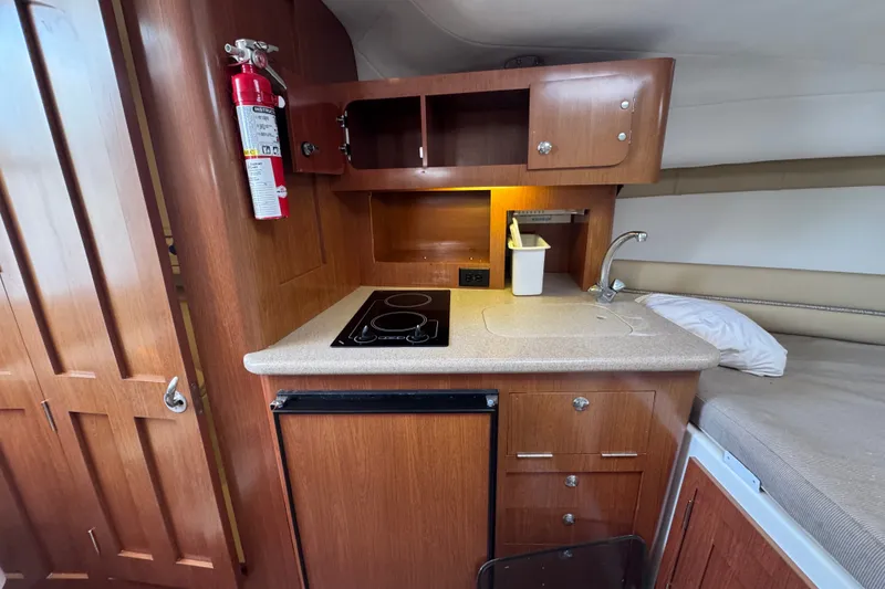 Slide: The Image of Compact kitchen area in a 2006 Pro-Line 35 Express boat with stove, sink, and storage. - 17