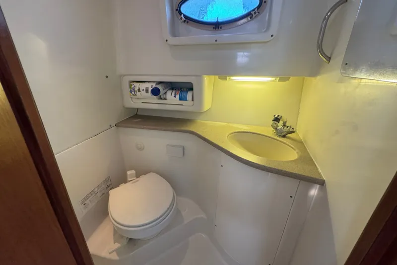 Slide: The Image of Bathroom interior of 2006 Pro-Line 35 Express boat, featuring toilet, sink, and storage. - 18