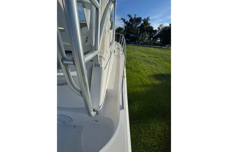 Slide: The Image of 2006 Pro-Line 35 Express boat deck with railing, viewed from the side, against a grassy background. - 36