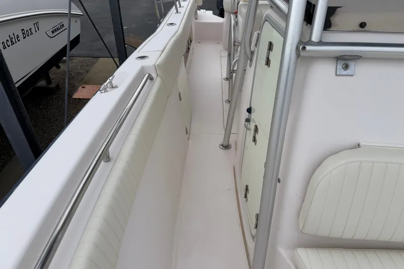 Slide: The Image of 2002 Grady White 273 Chase boat interior with white seating and storage compartments. - 16