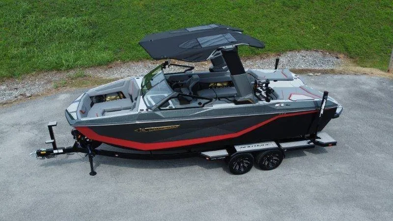The Image of A modern 2027 Nautique G23 boat on a trailer, featuring sleek design and a black canopy. - 1