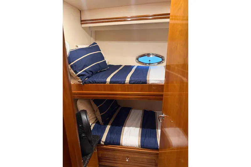 Slide: The Image of Bunk beds in 2002 Carver 570 Voyager Pilothouse with blue-striped bedding and wooden interior. - 15