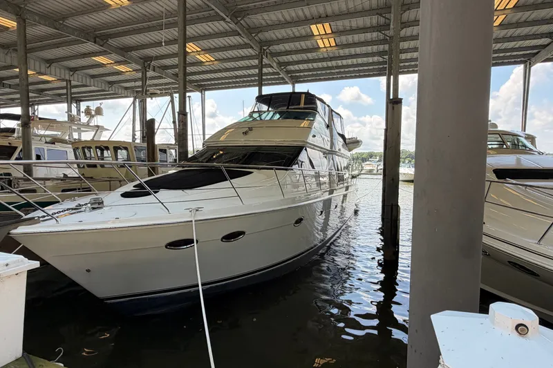 The Image of 2002 Carver 570 Voyager Pilothouse yacht docked in a covered marina. - 2