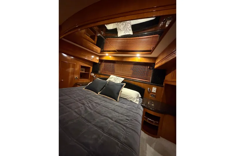 Slide: The Image of Luxurious cabin interior of 2002 Carver 570 Voyager Pilothouse with cozy bedding and wood accents. - 16