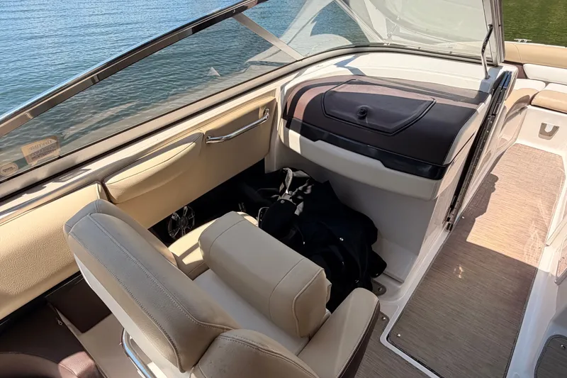 Slide: The Image of 2017 Regal 2700 ES Bowrider interior with beige seating and storage compartment. - 8