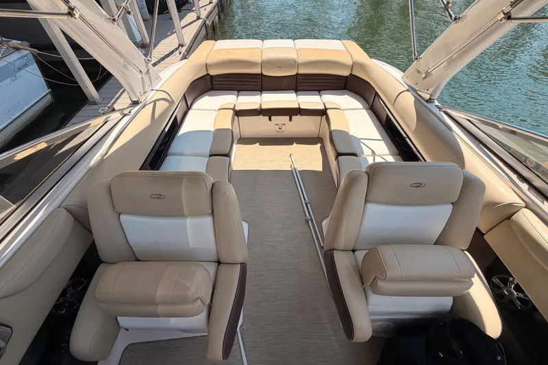 Slide: The Image of 2017 Regal 2700 ES Bowrider interior with beige seating, docked by the water. - 7