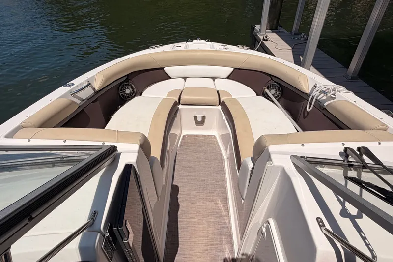 Slide: The Image of 2017 Regal 2700 ES Bowrider boat interior with beige seating and water view. - 10
