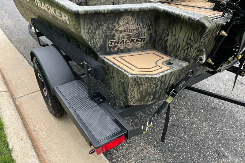 Slide: The Image of 2026 Tracker Grizzly 1650 T Prairie Wings Edition boat on trailer, camo design. - 13