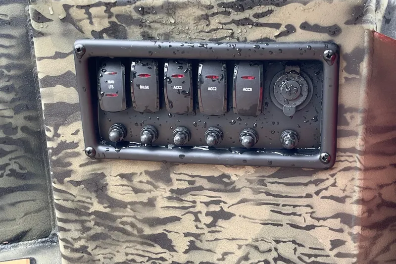 Slide: The Image of Control panel of 2026 Tracker Grizzly 1650 T Prairie Wings Edition with switches and camo design. - 26