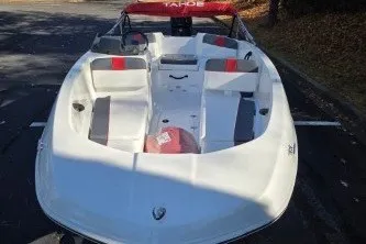 Slide: The Image of 2026 Tahoe T16 boat with red and gray seating, parked outdoors. - 68