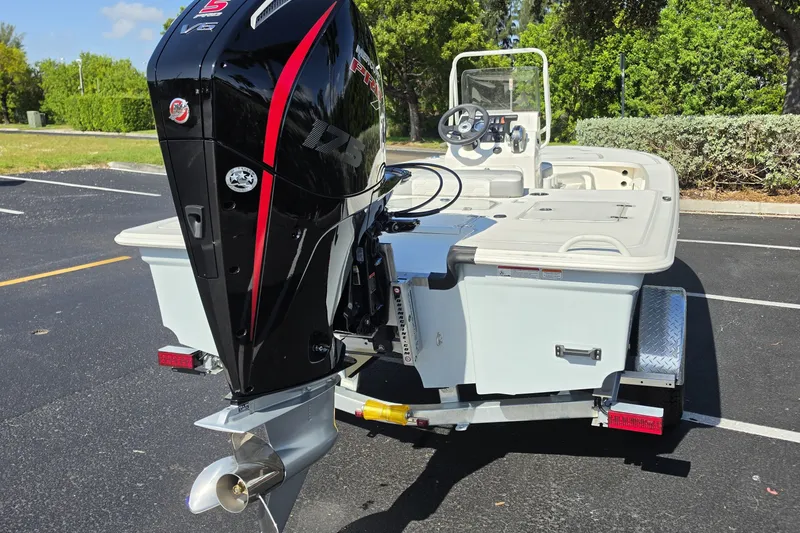 Slide: The Image of 2026 Mako 18 Pro Skiff with powerful outboard motor in a parking lot. - 16
