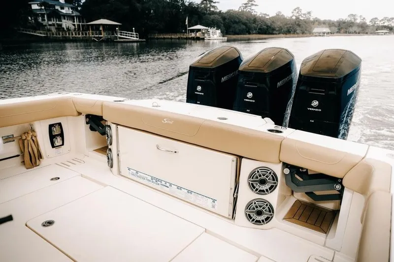 Slide: The Image of 2022 Scout 425 LXF boat with triple Mercury Verado engines on a calm waterway. - 8