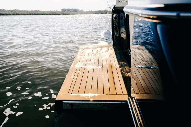 Slide: The Image of 2022 Scout 425 LXF boat with wooden deck on calm water. - 14