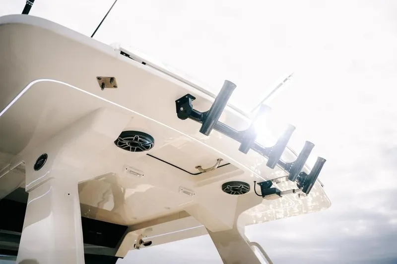 Slide: The Image of 2022 Scout 425 LXF boat with rod holders and speakers under bright sky. - 33