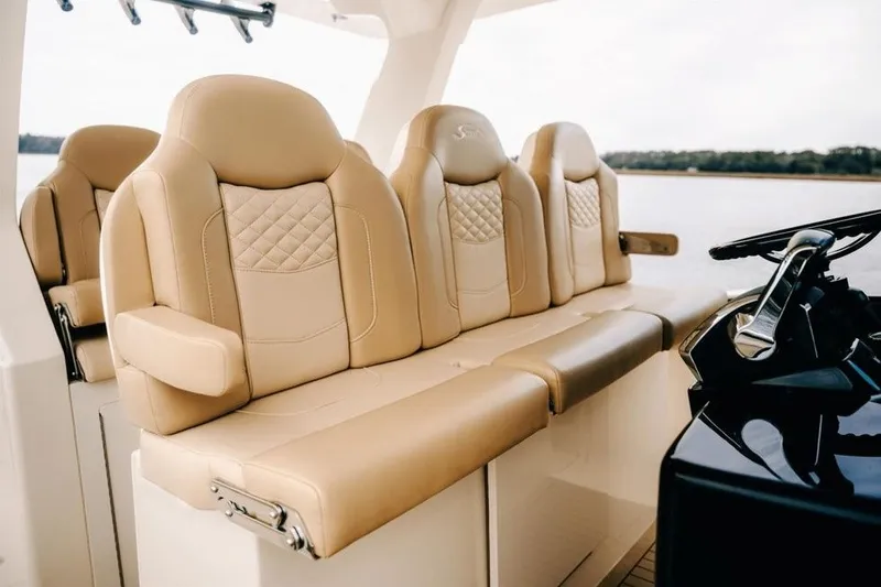 Slide: The Image of Luxurious beige seating on 2022 Scout 425 LXF boat, featuring quilted design and armrests. - 16