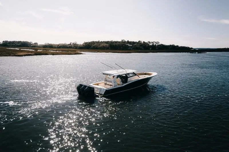 Slide: The Image of 2022 Scout 425 LXF boat cruising on a sunny, sparkling waterway. - 37