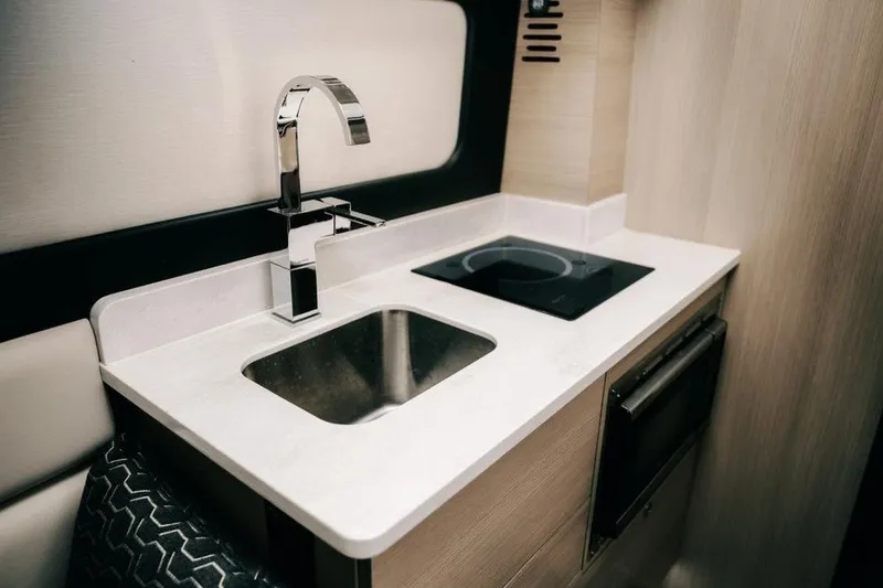 Slide: The Image of Modern kitchen area in 2022 Scout 425 LXF boat, featuring sink and stovetop. - 32