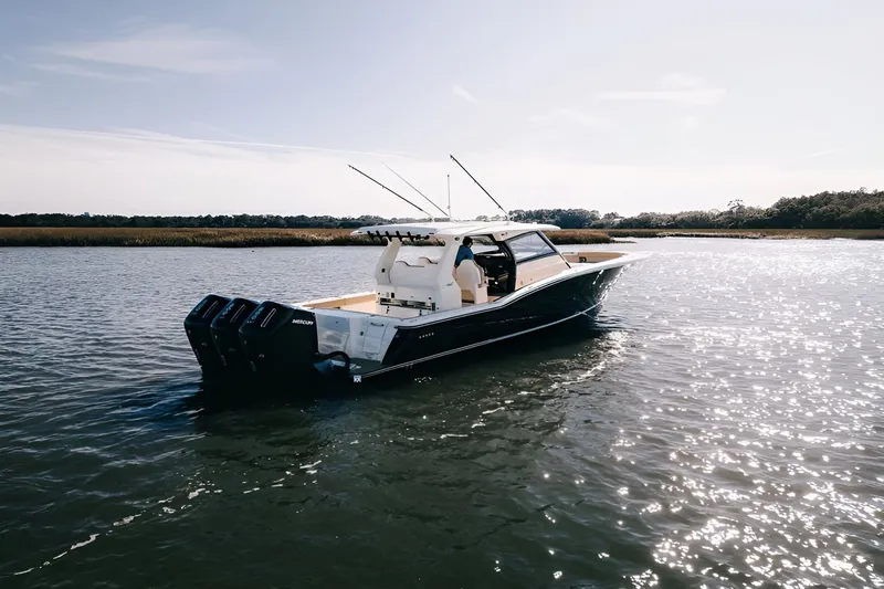 Slide: The Image of 2022 Scout 425 LXF boat cruising on a sunny, tranquil waterway. - 2