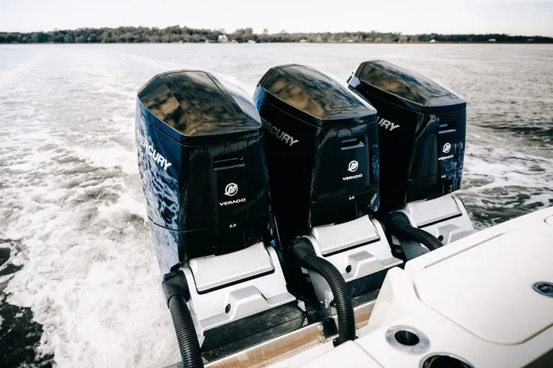 Slide: The Image of Triple Mercury Verado engines powering a 2022 Scout 425 LXF boat on open water. - 6