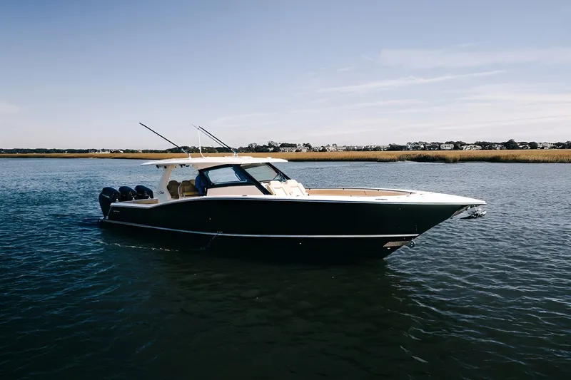The Image of 2022 Scout 425 LXF boat on calm water, showcasing sleek design and powerful engines. - 0