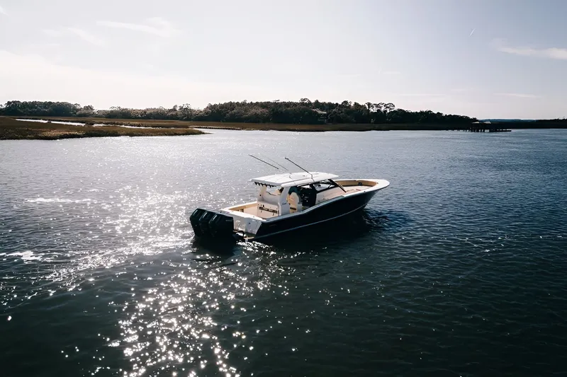 Slide: The Image of 2022 Scout 425 LXF boat cruising on a sunlit lake. - 3