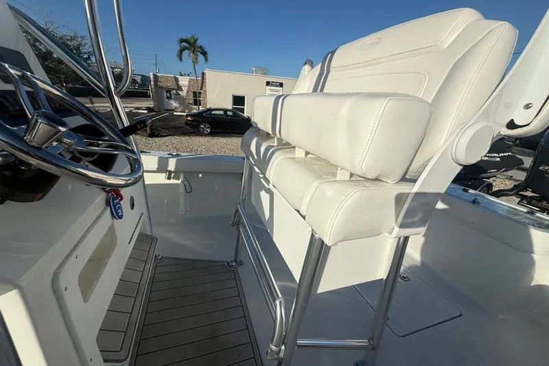 Slide: The Image of 2021 Pair Customs 21 Center Console MV boat interior with white seating and steering wheel. - 15