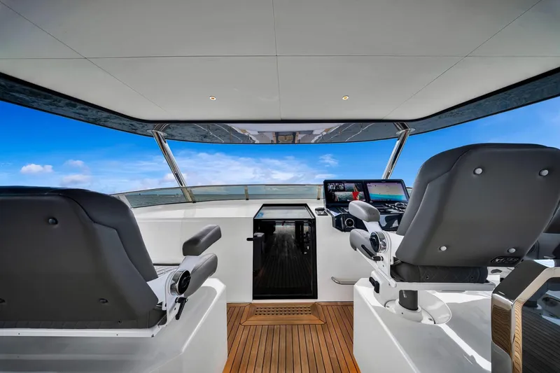 Slide: The Image of Interior view of 2021 Sirena 88 yacht helm with modern controls and ocean backdrop. - 23
