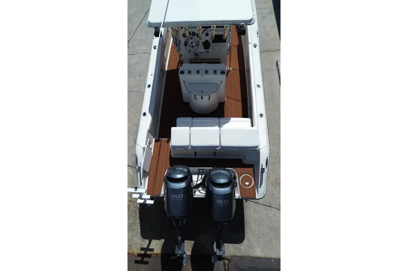 Slide: The Image of 2005 Triton 2690 CC boat with dual 150 horsepower engines, featuring spacious deck layout. - 14