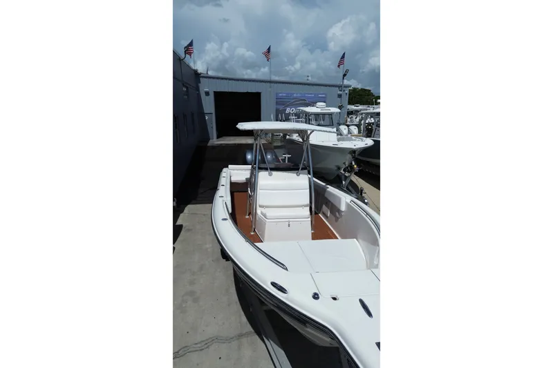 Slide: The Image of 2005 Triton 2690 CC boat docked at a marina under a cloudy sky. - 17
