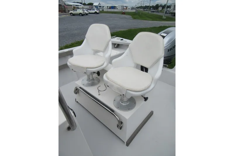 Slide: The Image of Two white swivel seats on a 2015 Allied 17 Sportsman boat. - 18
