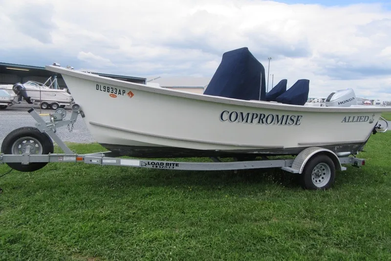 Slide: The Image of 2015 Allied 17 Sportsman boat named "Compromise" on a trailer, parked on grass. - 4