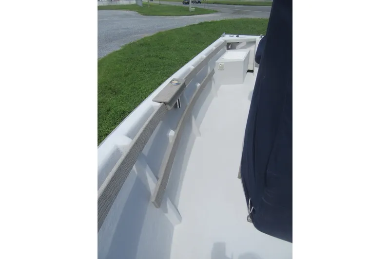Slide: The Image of 2015 Allied 17 Sportsman boat interior with seating and storage, docked on grass. - 11