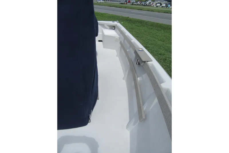 Slide: The Image of 2015 Allied 17 Sportsman boat interior with seating and railing, near a grassy roadside. - 10
