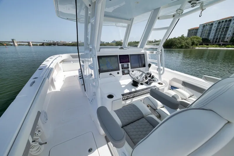 Slide: The Image of 2025 Invincible 35 Catamaran interior with modern helm, dual screens, and luxurious seating. - 32
