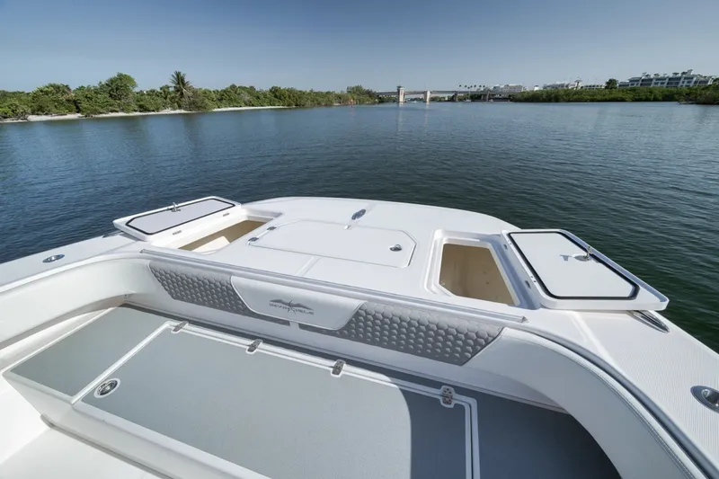 Slide: The Image of 2025 Invincible 35 Catamaran on calm water, showcasing spacious deck and storage compartments. - 18