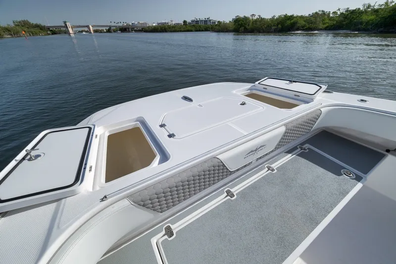 Slide: The Image of 2025 Invincible 35 Catamaran deck with storage compartments, on calm water. - 17