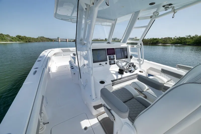 Slide: The Image of 2025 Invincible 35 Catamaran with modern helm, sleek design, and spacious deck on calm waters. - 28