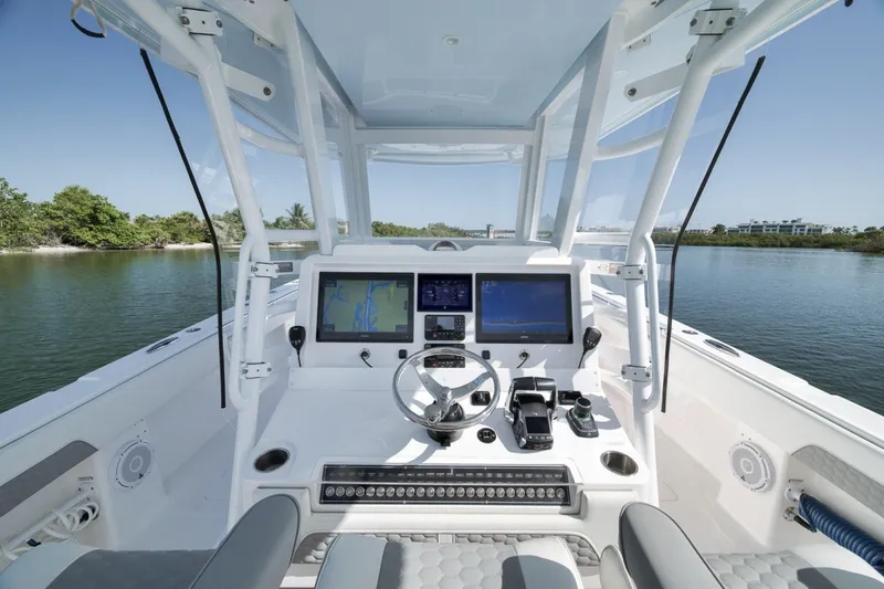 Slide: The Image of Cockpit of 2025 Invincible 35 Catamaran with advanced navigation systems on a serene waterway. - 33