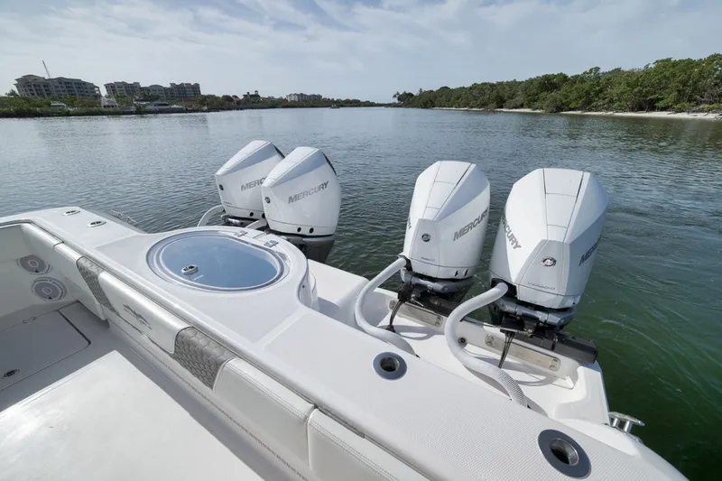 Slide: The Image of 2025 Invincible 35 Catamaran with triple Mercury engines on a serene waterway. - 44