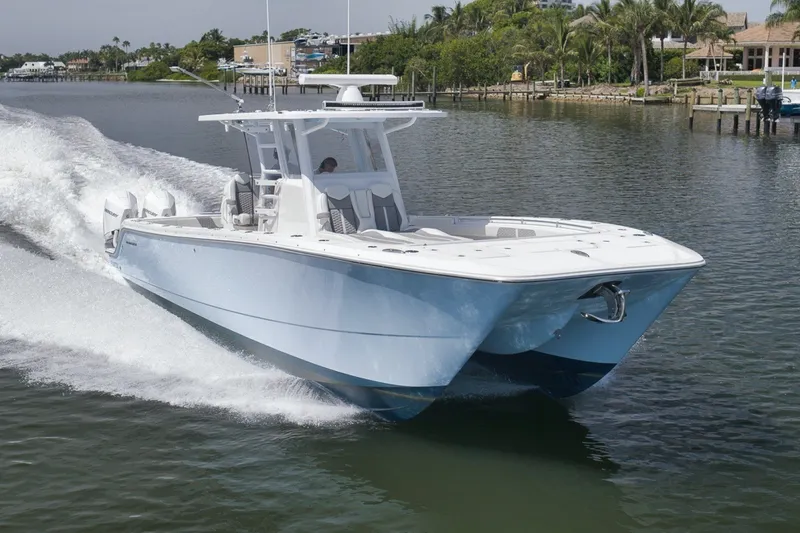 Slide: The Image of 2025 Invincible 35 Catamaran cruising on a scenic waterway. - 15