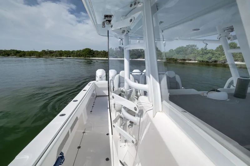 Slide: The Image of 2025 Invincible 35 Catamaran on calm water near a lush shoreline. - 35