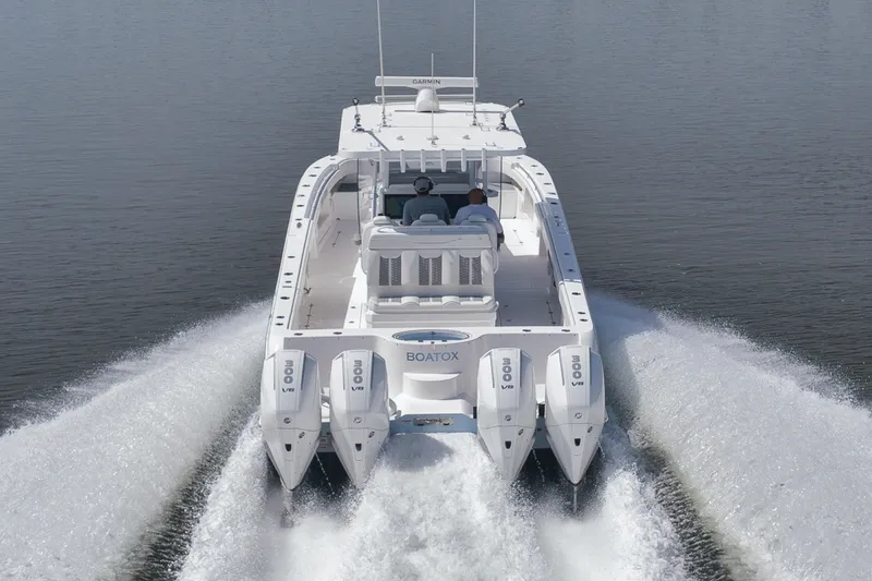 Slide: The Image of 2025 Invincible 35 Catamaran cruising on water, rear view with powerful engines. - 48