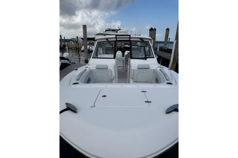 Slide: The Image of 2024 Southport 33 DC boat docked, showcasing spacious seating and sleek design. - 1