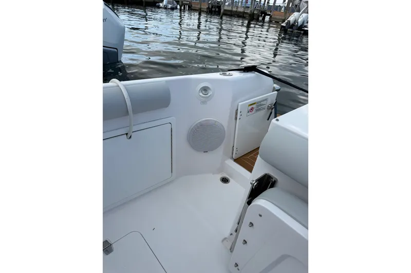 Slide: The Image of 2024 Southport 33 DC boat interior with storage compartments and speaker, docked by the water. - 37