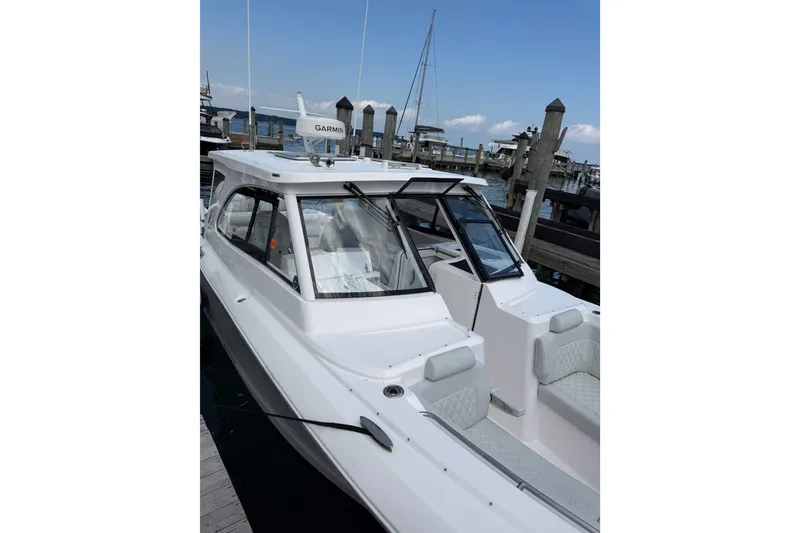 Slide: The Image of 2024 Southport 33 DC boat docked at marina, featuring sleek design and Garmin equipment. - 5