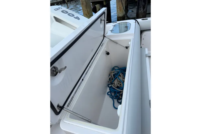 Slide: The Image of Open storage compartment on 2024 Southport 33 DC boat, containing coiled ropes. - 28