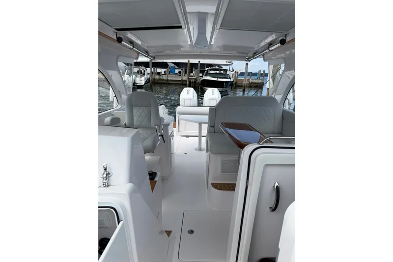 Slide: The Image of 2024 Southport 33 DC boat interior with seating and dock view. - 38