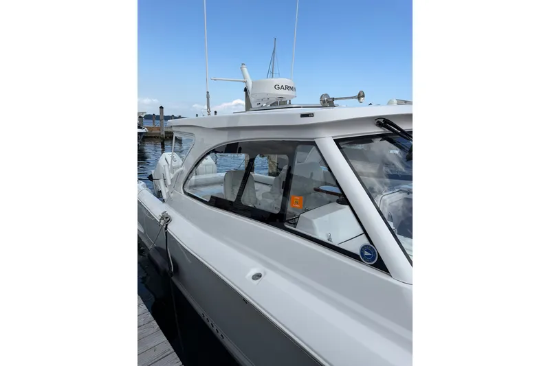 Slide: The Image of 2024 Southport 33 DC boat docked, featuring sleek design and Garmin equipment. - 2